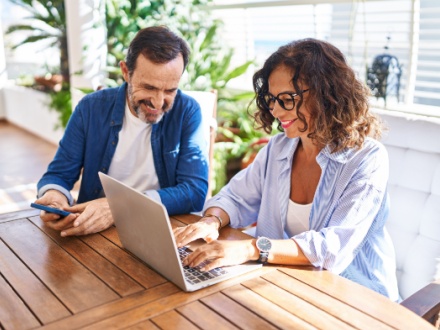 middle aged couple at home on laptop