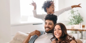 happy parents at home playing with child