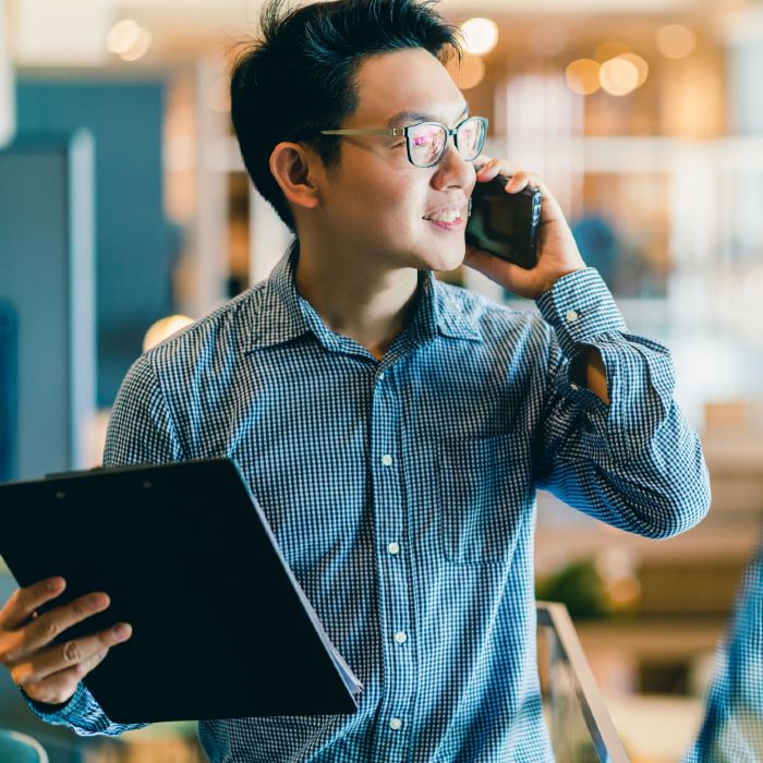 Young Asian man holding black flip folder