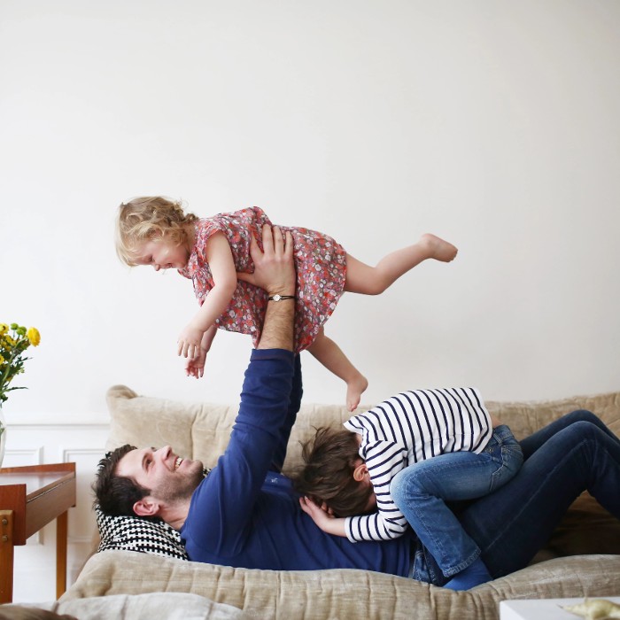 father at home playing with children