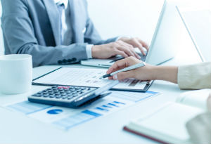 business meeting with laptop and calculator on table