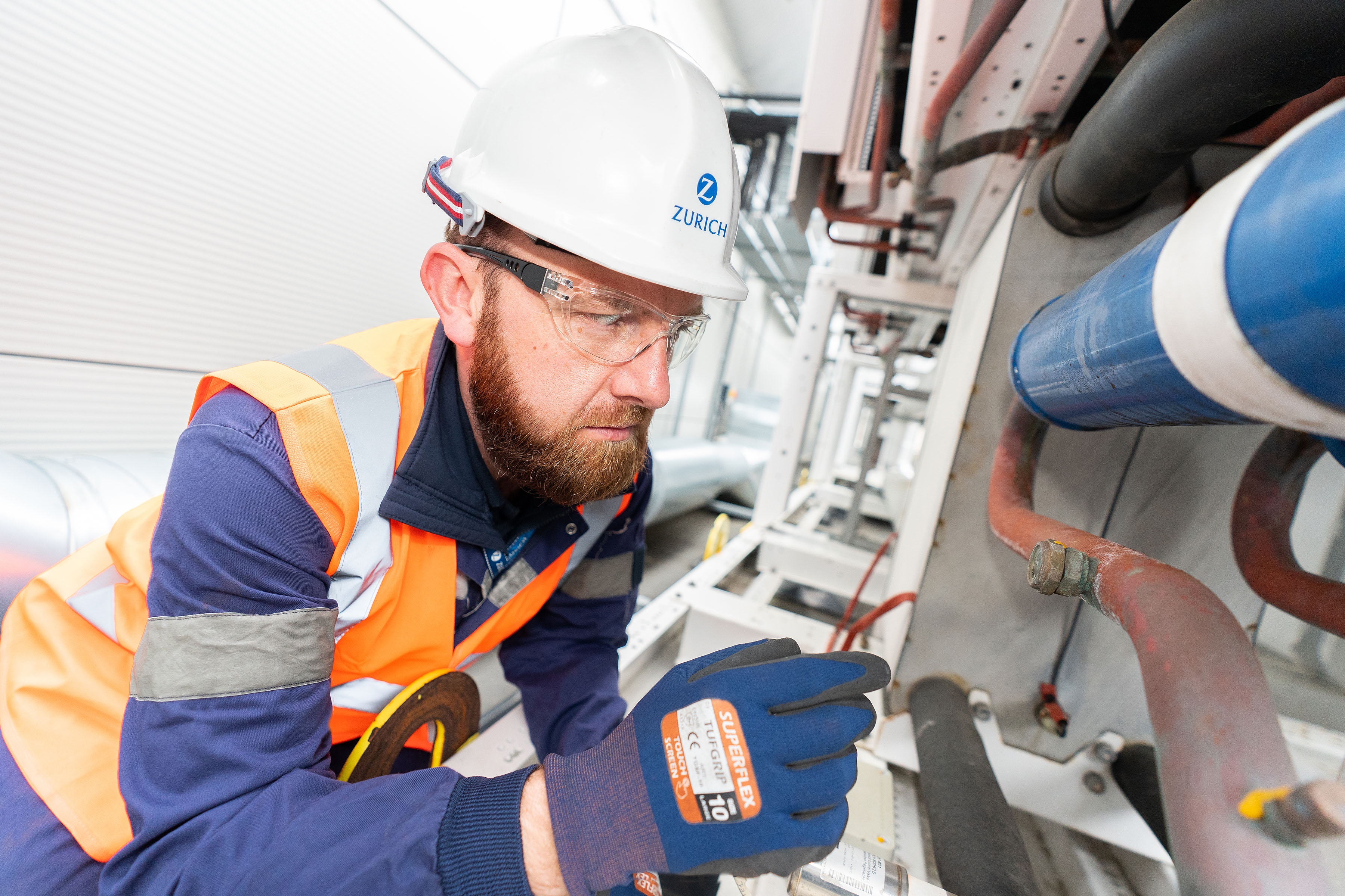 Construction worker inspecting pipes