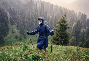 man walking in the rain in blue raincoat